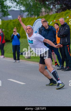 Un concurrent lance le ballon, Championnat d'Europe 2022 Boßeln ou balle de tir à Süderhastedt Dithmarschen, Schleswig-Holstein, Allemagne du Nord Banque D'Images