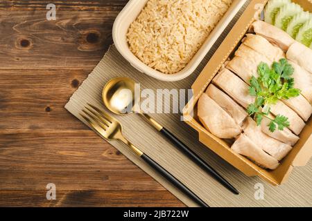 Riz au poulet Hainanese (riz au poulet de Singapour) célèbre nourriture de singapour et cuisine thaïlandaise sur table en bois sombre. Cuisine asiatique. Banque D'Images