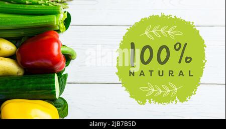 Image de 100 pour cent de texte naturel en vert sur légumes frais biologiques sur des planches de bois Banque D'Images