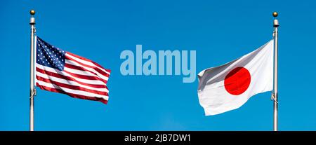 Drapeaux des Etats-Unis et du Japon contre le ciel bleu, concept politique image Banque D'Images