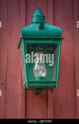 Ancienne lampe rétro verte sur fond de bois rouge. Banque D'Images