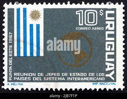 URUGUAY - VERS 1967 : un timbre imprimé en Uruguay montre le drapeau de l'Uruguay et la carte des Amériques, Réunion des présidents américains, Punta del Este, ci Banque D'Images