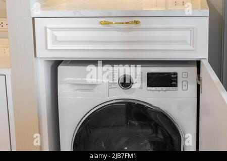 Gros plan sur le panneau de commande du lave-linge blanc dans la buanderie. Banque D'Images