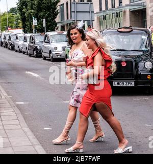 Epson Surrey, Londres Royaume-Uni, 03 juin 2022, Two Young Women Crossing Road en robes serrées à la mode Banque D'Images