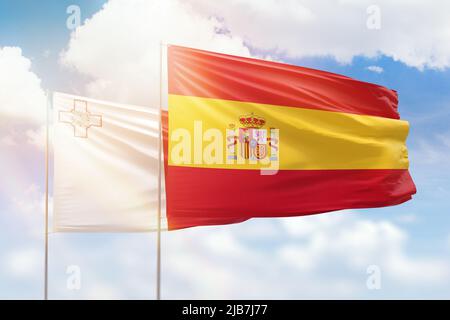 Ciel bleu ensoleillé et drapeaux de l'espagne et de malte Banque D'Images