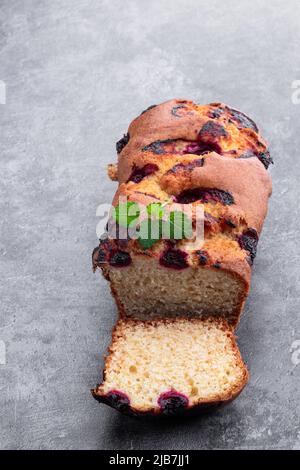 Pain de gâteau frais maison avec cerise sucrée sur fond gris Banque D'Images