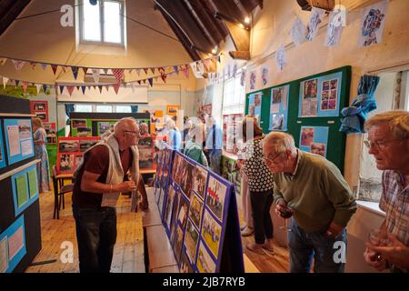 Les résidents des environs de tous âges voient des centaines d'images sont mises en exposition dans le Village Hall, couvrant l'histoire entière du petit village de South Devon, dans le cadre des célébrations du Jubilé de platine. Crédit : nouvelles en direct de will Tudor/Alamy Banque D'Images