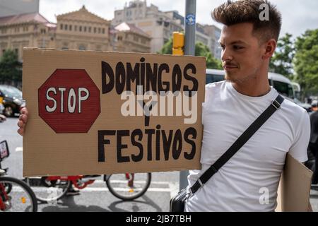 Barcelone, Espagne. 03rd juin 2022. Un démonstrateur tient une affiche contre la prolongation des heures d'ouverture commerciale jusqu'au dimanche pendant la démonstration. Criant « nous voulons concilier travail et famille », Les syndicalistes et les travailleurs du secteur de la vente au détail ont manifesté devant les boutiques emblématiques du Passeig de Gràcia pour protester contre l'extension des heures de travail aux dimanches approuvée par le Gouvernement de la Generalitat de Catalogne et ratifiée par le Conseil municipal de Barcelone afin de définir un nouvelle zone touristique pour ouverture commerciale. Crédit : SOPA Images Limited/Alamy Live News Banque D'Images