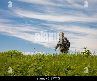 Une femme mûre marchant dans un parc vert le jour ensoleillé du printemps. Photo de voyage, mise au point sélective, espace de copie pour texte-29 mai,2022-Delta BC Canada Banque D'Images