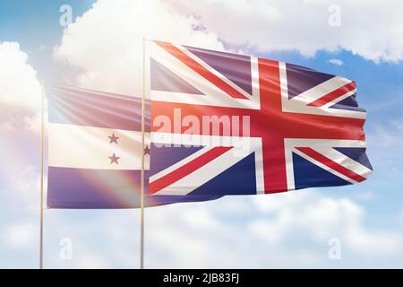 Ciel bleu ensoleillé et drapeaux du royaume-uni et du honduras Banque D'Images