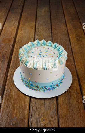 Gâteau à la vanille avec glaçage à la crème au beurre, décoré de saupoudres colorées vertical. Banque D'Images