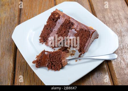 Gros plan d'une fourchette avec un morceau de gâteau au chocolat rempli de ganache au chocolat semisweet. Banque D'Images