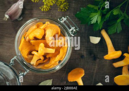 Conserver les chanterelles dans un pot aux épices et aux herbes.Pickling de champignons sauvages comestibles.Mise à plat, vue de dessus Banque D'Images