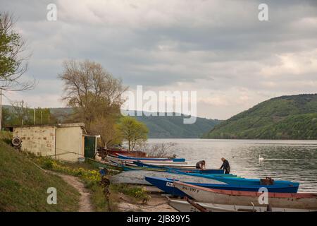 Photo de deux hommes préparant des bateaux de pêche près du village serbe de Banatska Palanka sur le Danube. Le village est situé dans le gorg du Danube Banque D'Images