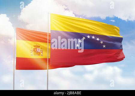 Ciel bleu ensoleillé et drapeaux du venezuela et de l'espagne Banque D'Images