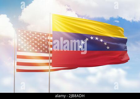 Ciel bleu ensoleillé et drapeaux du venezuela et des états-unis Banque D'Images