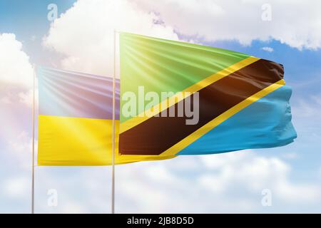 Ciel bleu ensoleillé et drapeaux de la tanzanie et de l'ukraine Banque D'Images