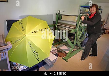 Rothen, Allemagne. 03rd juin 2022. Heidrun Klimmey se tient dans son atelier à Rothener Hof, où elle fabrique des imprimés. Un parapluie jaune avec l'inscription 'Kunst offen' (Art Open) invite les visiteurs à voir l'atelier et une exposition 'Zwischen uns' (entre nous) par cinq artistes féminins. Au cours de la campagne nationale « Art Open », quelque 900 artistes de plus de 500 sites ouvriront leurs ateliers et leurs studios aux visiteurs le week-end de Whitsun à 4-6 juin 2022. Credit: Bernd Wüstneck/dpa/Alay Live News Banque D'Images