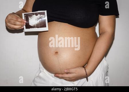 jeunes femmes enceintes montrant son sonogramme avec ventre rond ventre womb de différents angles Banque D'Images