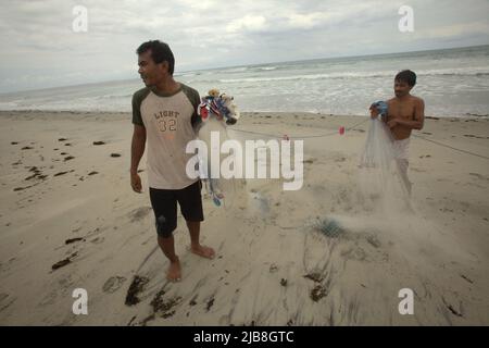 Pêcheurs organisant des filets de pêche sur la plage de Kalala à Wula, Wula Waijelu, East Sumba, East Nusa Tenggara, Indonésie. Banque D'Images