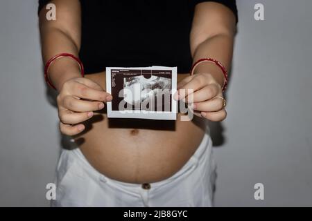 jeunes femmes enceintes montrant son sonogramme avec ventre rond ventre womb de différents angles Banque D'Images