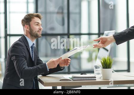 Gros plan sur un homme d'affaires qui prend des dossiers à portée de main Banque D'Images