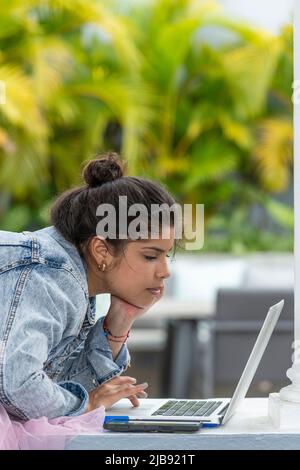 Portrait d'une jeune femme latine utilisant un ordinateur portable à l'extérieur - photo de stock Banque D'Images