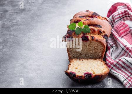 Pain de gâteau frais maison avec cerise sucrée sur fond gris Banque D'Images