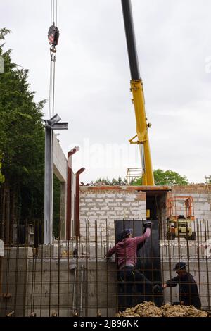 homme travaillant sur le chantier de construction maison privée et structures en béton armé du bâtiment en construction. échafaudage. Grue Banque D'Images