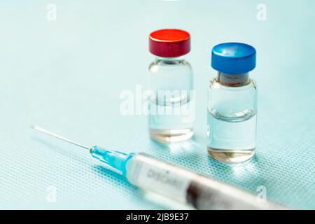 Vaccin en capsules rouges et bleues avec une seringue sur fond bleu. Le concept de médecine, de santé et de science. Vaccin contre le coronavirus. Station santé Copy Banque D'Images