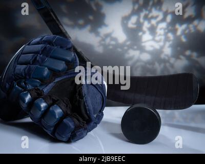 Helsinki / Finlande - 4 JUIN 2022 : gros plan de l'équipement de hockey sur glace sur fond sombre. Casque, bâton, palet et gants de hockey sur glace Banque D'Images