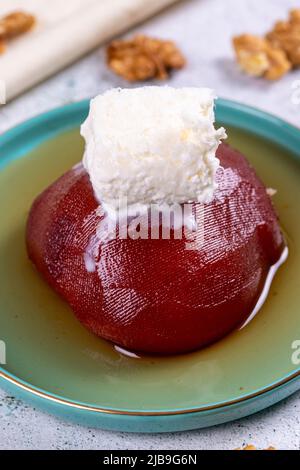 Dessert de coing. Spécialités turques traditionnelles. Dessert de coing avec crème sur fond de pierre. Gros plan. Nom local ayva tatlisi Banque D'Images