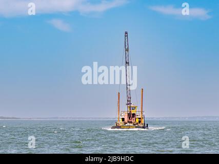 Petite barge avec une grue dans la rivière Peconic Banque D'Images