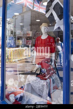 La fenêtre décorée du Jubilé de platine du Queens est ornée d'un mannequin et de drapeaux Union et Cornish. Les bâtiments en face se reflètent dans la lumière du soleil Banque D'Images