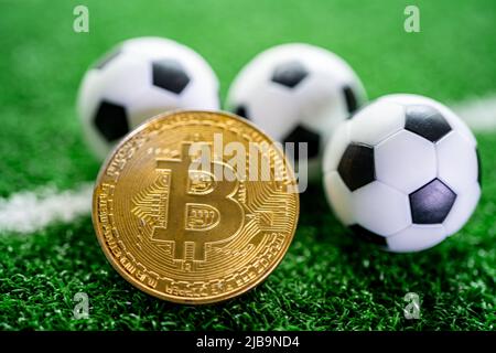 Bitcoin d'or avec ballon de football ou de football, crypto-monnaie utilisée dans les Paris sportifs en ligne. Banque D'Images