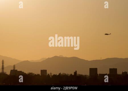 Kanagawa, Japon. 4th décembre 2021. Un hélicoptère Sikorsky CH53 Super Stallion avec le US Marine corps est vu dans la silhouette contre un ciel de coucher de soleil car il survole des bâtiments tout en atterrissant à la base aérienne de Naval Air Facility Atsugi. Kanagawa. (Image de crédit : © Damon Coulter/SOPA Images via ZUMA Press Wire) Banque D'Images