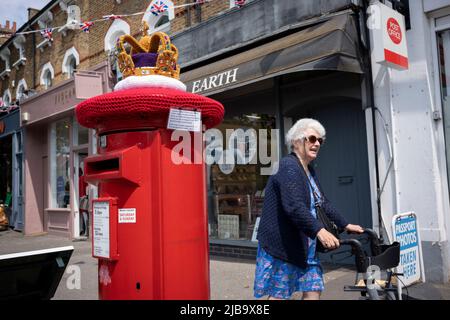 Une couronne en maille crochetée se trouve au-dessus d'une boîte postale de Royal Mail dans le village de Dulwich pendant le long week-end des fêtes de la Banque pour célébrer le Jubilé de platine de la reine, le 4th juin 2022 à Londres, en Angleterre. La reine Elizabeth II est sur le trône du Royaume-Uni depuis 70 ans, le monarque le plus longtemps au service de l'histoire anglaise et tout au long du week-end du Jubilé, le public organise des fêtes de rue et des rassemblements communautaires. Banque D'Images