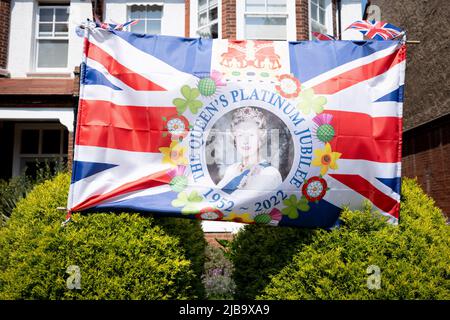 Le visage de la reine sourit aux passants, depuis le jardin avant d'une propriété résidentielle de Dulwich pendant le long week-end des fêtes de la banque pour célébrer le Jubilé de platine de la reine, le 4th juin 2022 à Londres, en Angleterre. La reine Elizabeth II est sur le trône du Royaume-Uni depuis 70 ans, le monarque le plus longtemps au service de l'histoire anglaise et tout au long du week-end du Jubilé, le public organise des fêtes de rue et des rassemblements communautaires. Banque D'Images