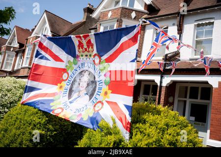 Le visage de la reine sourit aux passants, depuis le jardin avant d'une propriété résidentielle de Dulwich pendant le long week-end des fêtes de la banque pour célébrer le Jubilé de platine de la reine, le 4th juin 2022 à Londres, en Angleterre. La reine Elizabeth II est sur le trône du Royaume-Uni depuis 70 ans, le monarque le plus longtemps au service de l'histoire anglaise et tout au long du week-end du Jubilé, le public organise des fêtes de rue et des rassemblements communautaires. Banque D'Images