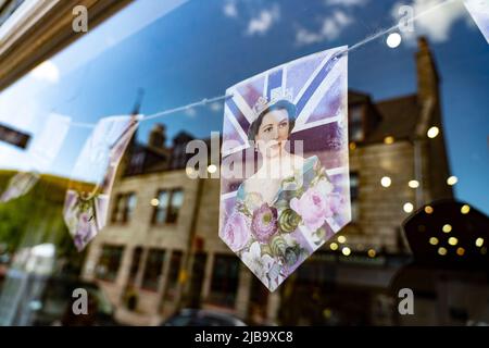 Ballater, Écosse, Royaume-Uni. 4 juin 2022. La célébration du Jubilé de platine de la Reine est jouée dans le village de Ballater, près de Balmoral, sur le Royal Deeside, dans l’Aberdeenshire. Photo ; Jubilé de platine, reflet de banderole dans une fenêtre de magasin. Iain Masterton/Alay Live News Banque D'Images
