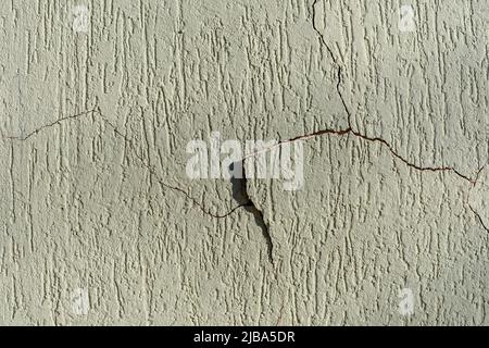 Peinture écaillée d'un mur de maison. Mur avec des fissures sur la peinture murale, texture de grafiato brésilien. Banque D'Images