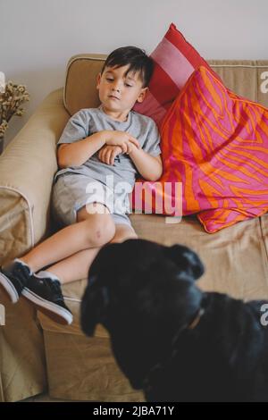 Petit garçon jouant avec un chien rottweiler Banque D'Images