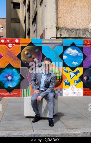 Ipswich Suffolk UK 27 mai 2022 : un homme d'affaires charmant en costume gris devant des œuvres d'art urbaines