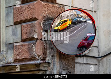 miroir de signalisation avec une ambulance jaune, voiture d'urgence garée sur le côté de la rue Banque D'Images