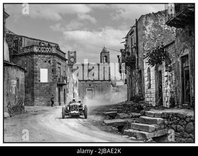 Vintage 1930 Targa Florio avec le vainqueur Achille Varzi dans son Alfa Romeo P2 passant par un village rural sicilien. Le Targa Florio 1930 était une course automobile de Grand Prix qui n'avait pas de championnat et qui s'est déroulée sur un parcours de 108 km (67 miles) composé de routes publiques sur l'île italienne montagneuse de Sicile. Banque D'Images