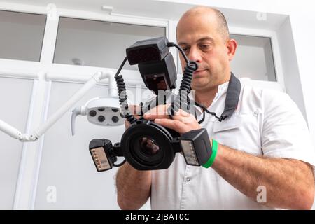 Dentiste photographiant les dents du patient à des fins de dossier médical avant et après la chirurgie dans le cabinet du dentiste Banque D'Images