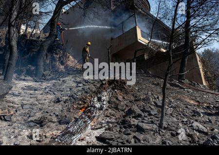 Athènes, Grèce. 4th juin 2022. Les pompiers combattent un incendie dans une maison de Voula, dans la banlieue sud d'Athènes, en Grèce, sur 4 juin 2022. Un important feu de forêt a éclaté samedi après-midi dans la partie côtière sud d'Athènes, ce qui a poussé le service d'incendie à réagir au moment où l'incendie attelait les zones résidentielles. Crédit: Marios Lolos/Xinhua/Alamy Live News Banque D'Images