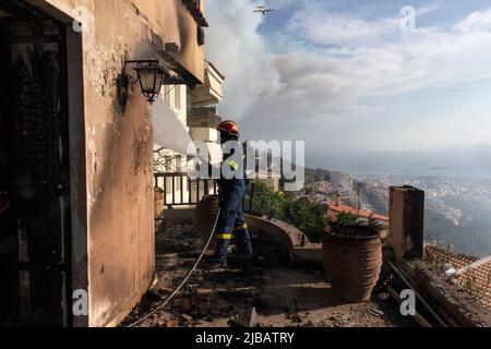 Athènes, Grèce. 4th juin 2022. Un pompier combat un incendie à l'extérieur d'une maison à Voula, dans la banlieue sud d'Athènes, en Grèce, sur 4 juin 2022. Un important feu de forêt a éclaté samedi après-midi dans la partie côtière sud d'Athènes, ce qui a poussé le service d'incendie à réagir au moment où l'incendie attelait les zones résidentielles. Crédit: Marios Lolos/Xinhua/Alamy Live News Banque D'Images