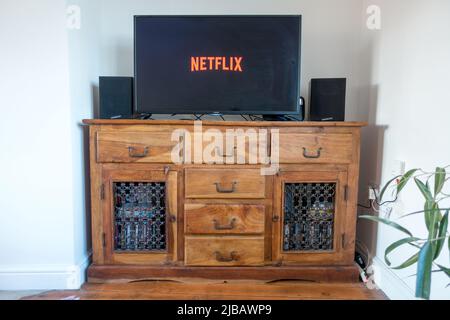 Service de diffusion Netflix sur la TV au-dessus de la table antique Banque D'Images