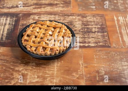 Tarte à la banane maison à la cannelle et à la croûte dorée, sur fond de bois Banque D'Images